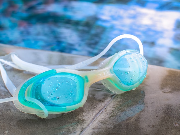 Premium Photo | Blue modern swim goggles placed beside the pool.