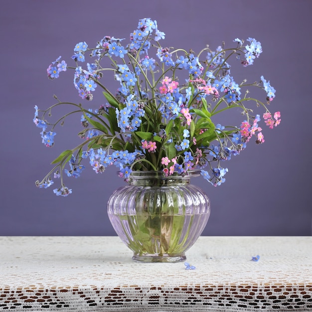 Premium Photo Blue And Pink Forget Me Nots Myosotis Small Bouquet Of Flowers In A Glass Vase On A Purple Background