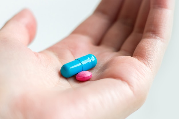 premium-photo-blue-and-pink-pill-capsule-on-the-female-palm-on-white