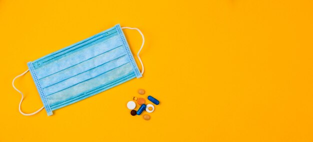 Download Premium Photo Blue Protective Medical Mask On Yellow Background Surrounded With Colorful Pills Creative Concept Of Healthcare Hygiene Virus Protection And Medical Treatment On Coronavirus Quarantine Yellowimages Mockups