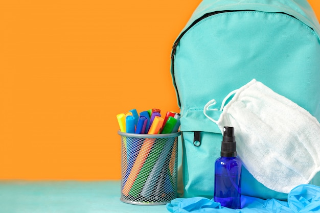 Premium Photo | Blue school backpack with mask, hand sanitizer and ...