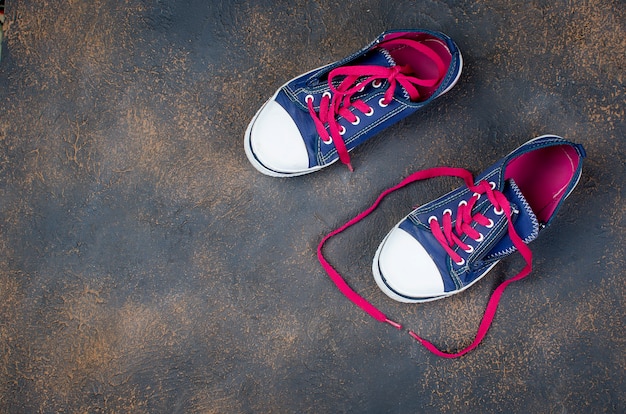 Premium Photo | Blue sports shoes with pink shoelaces on the floor