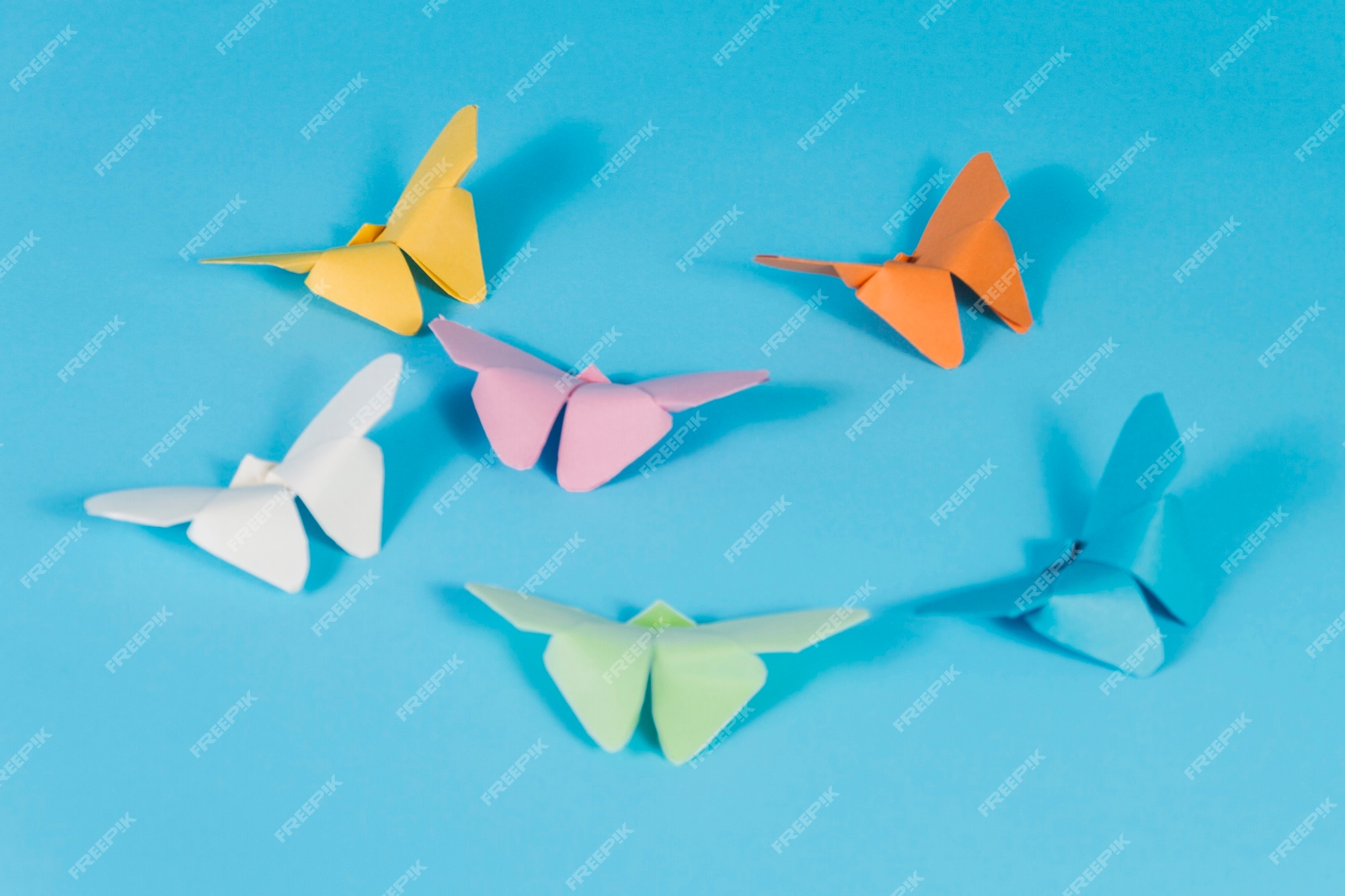 Free Photo | Blue surface with paper butterflies