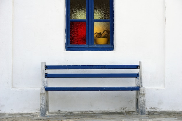 Blue Wooden Bench Under Beautiful Blue Window Frame On White Wall