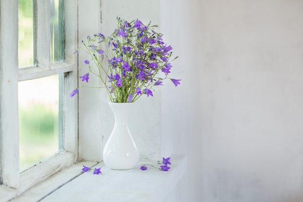 Premium Photo | Bluebells in vase on windowsill