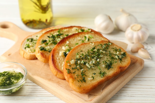 Premium Photo | Board with garlic bread on white wooden