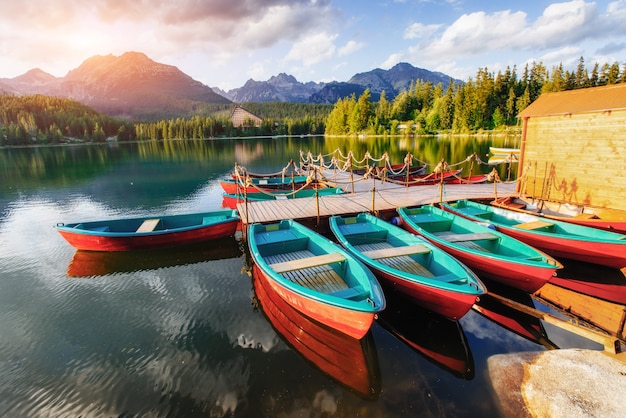 Premium Photo | Boat on the dock surrounded by mountains at sunset.
