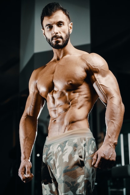 Premium Photo Bodybuilder Strong Man Pumping Up Abs Muscles