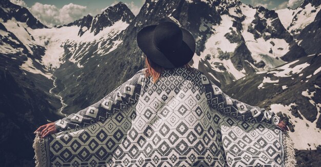 Premium Photo Boho Woman Wearing Hat And Poncho Standing By The Mountain