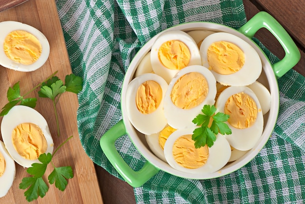 Boiled eggs in a bowl decorated with parsley leaves Free Photo