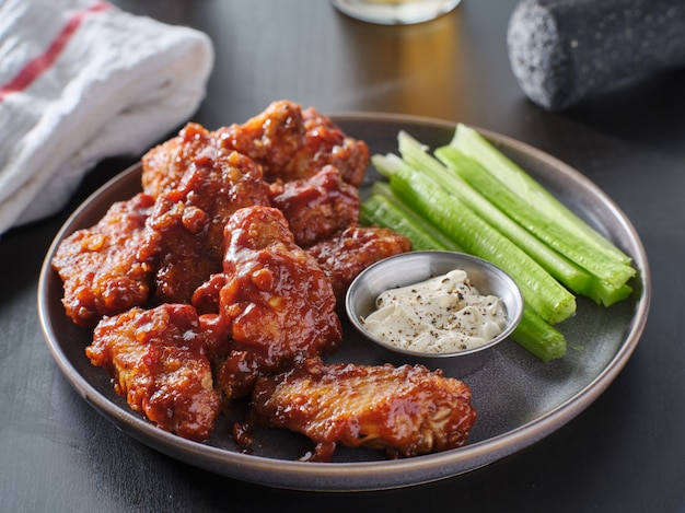 Premium Photo Boneless Chicken Wings Covered In Honey Garlic Bbq Sauce With Ranch And Celery