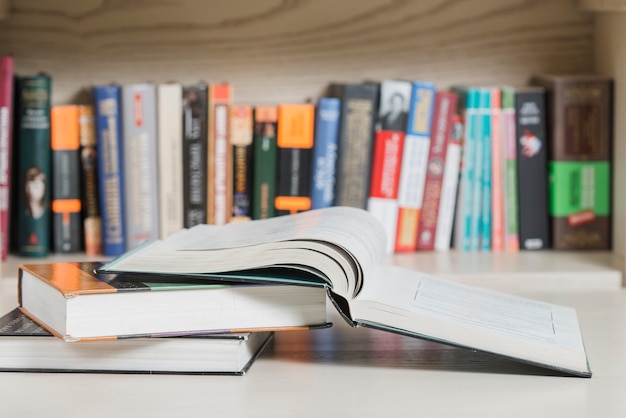 Books lying near bookshelf Free Photo
