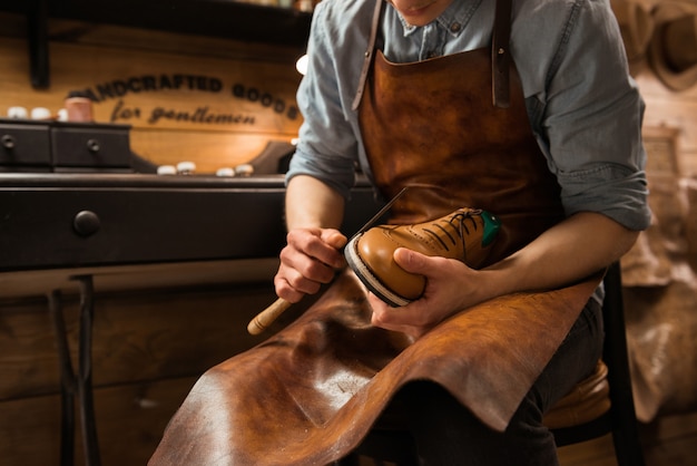 Free Photo | Bootmaker in workshop making shoes