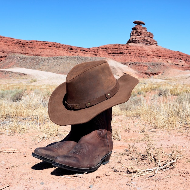 Premium Photo | Boots and hat in front of famous mexican hat rock