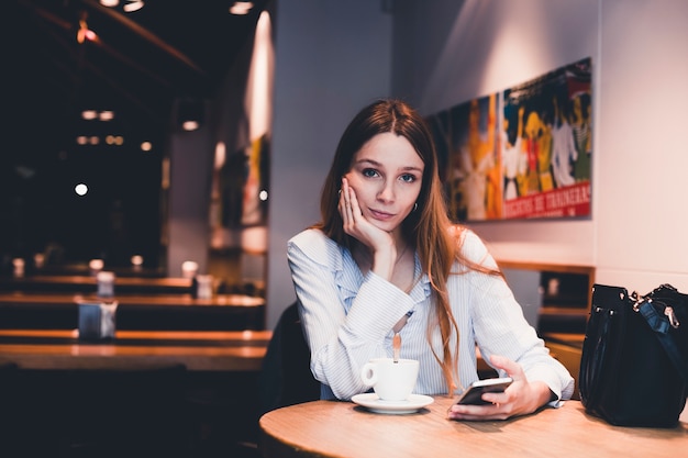 Free Photo | Bored woman with smartphone looking at camera