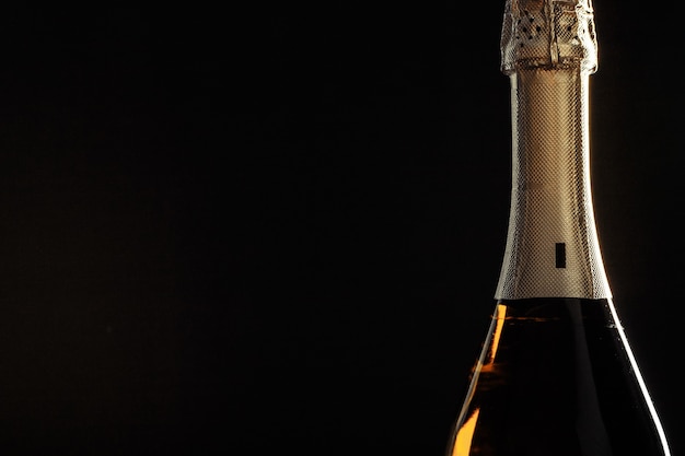 Premium Photo | Bottle of champagne on black background.