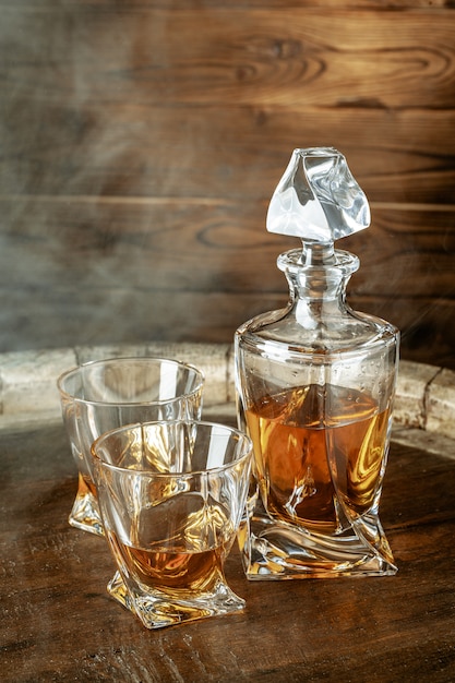 Premium Photo | A bottle of cognac and glass on a brown wooden . brandy