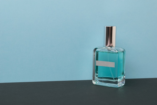 Premium Photo | A bottle with blue perfume on a black and blue ...