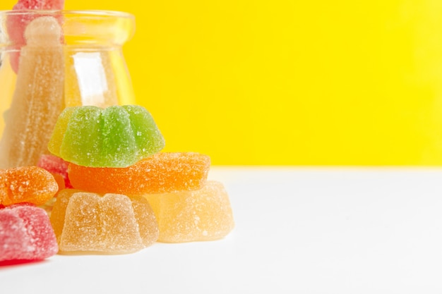Bottles with sweet candies on table background Premium Photo