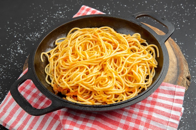 Free Photo | Bottom view spaghetti frying pan on wood board on black ...