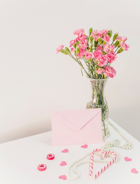 Bouquet Of Flowers In Vase Near Candy Canes Envelope And Beads On