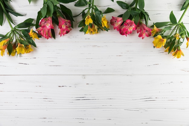 白い木製の織り目加工の背景にアルストロメリアの花の花束 無料の写真