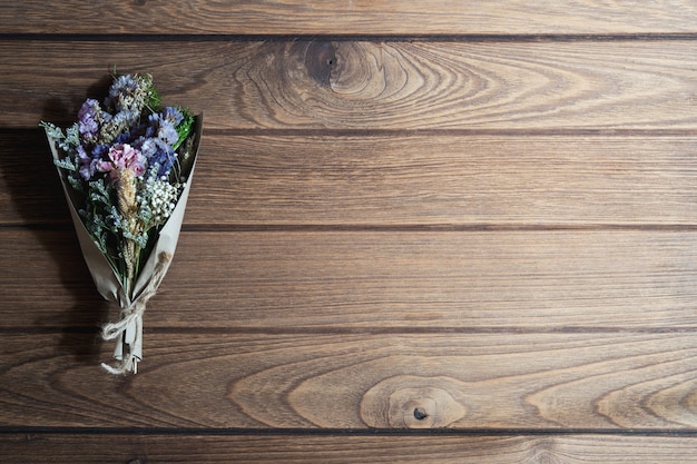 素朴な木製のテーブル背景に乾燥された野生の花の花束 プレミアム写真