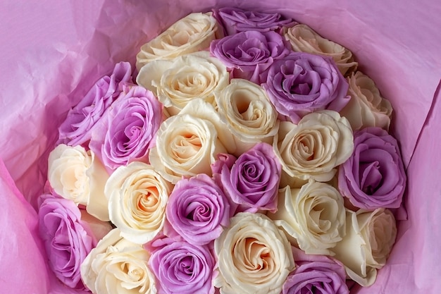 はがき カバー バナーの暗い背景にペーパークラフトで新鮮な驚くべき白と紫のバラの花束 贈り物として美しい花 プレミアム写真
