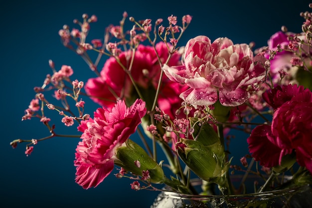 紺色の表面にガラスの花瓶のピンクのカーネーションの花束 母の日 誕生日グリーティングカード コピースペース プレミアム写真