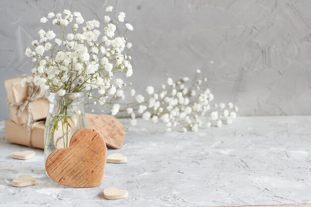 灰色の背景に小さな白い花と木の心の花束 プレミアム写真
