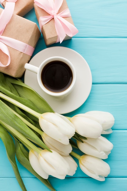 一杯のコーヒーとギフトとチューリップの花の花束 無料の写真