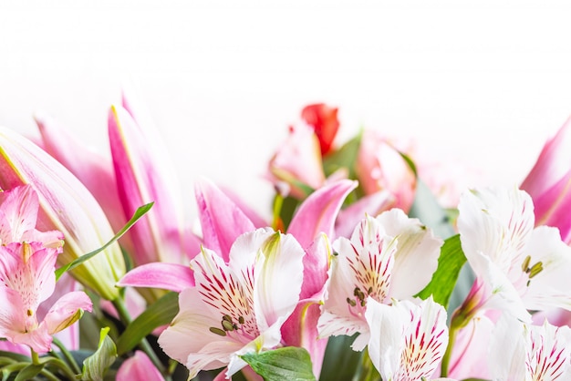 白いアルストロメリアの花と白地にピンクのユリのクローズアップの花束 テキスト コピースペースの空き領域を持つ花春の背景 美しい花が咲くと組成 プレミアム写真