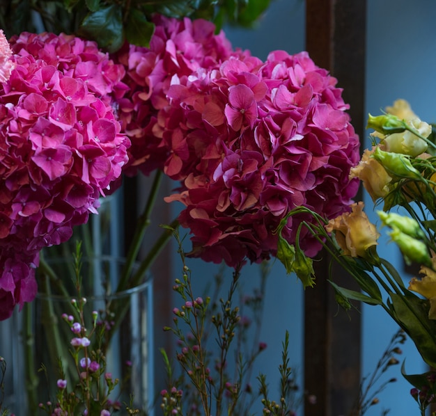 Free Photo A Bouquet Of Pink Flowers With Green Leaves Inside A Vase Standing On Room Wall