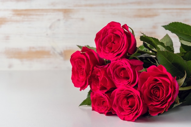 Premium Photo | Bouquet of red roses on wooden table.