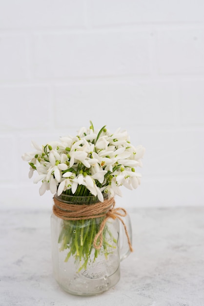 Premium Photo  Bouquet of spring flowers of snowdrops in a glass