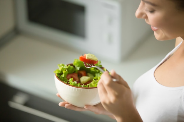 Bowl of fresh green salad hold in female hands Free Photo