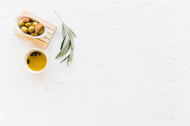 Bowl of olive with black pepper oil and twig Free Photo