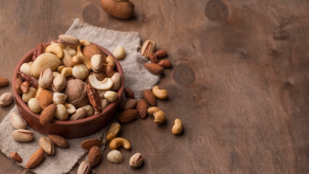 Bowl with nuts copy space wooden background Free Photo