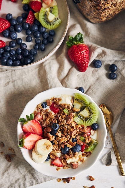 Free Photo | Bowls of granola with yogurt, fruits and berries on a ...