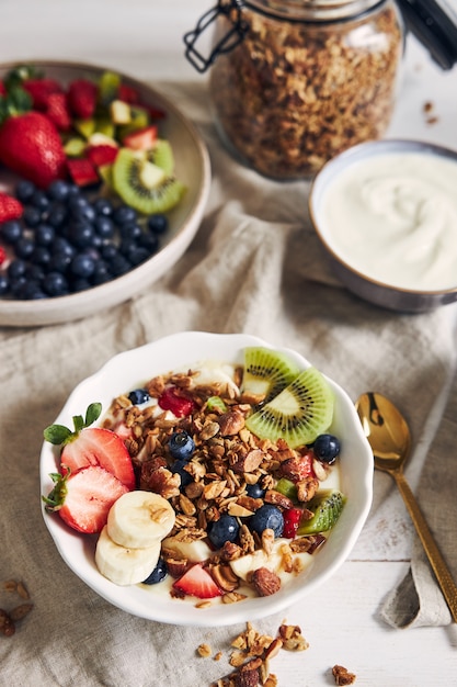 Free Photo | Bowls of granola with yogurt, fruits and berries on a ...