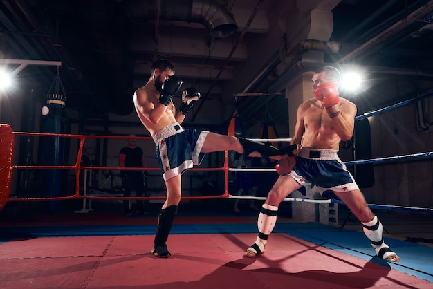 Premium Photo | Boxers training kickboxing in the ring