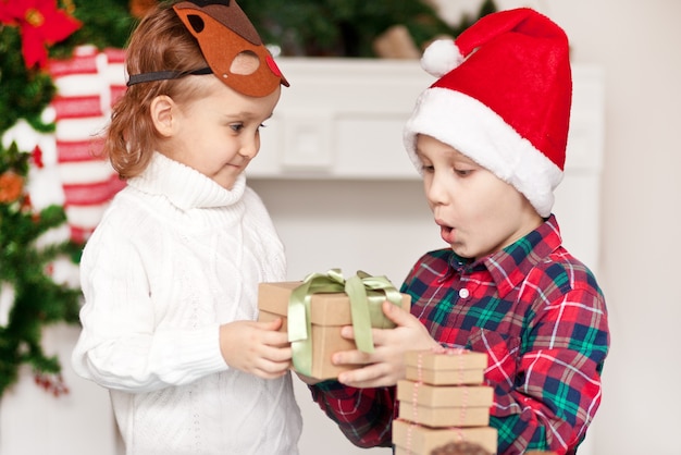 男の子と女の子の兄と妹はお互いにクリスマスプレゼントをします プレミアム写真