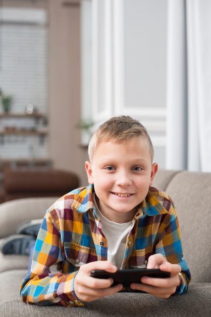 Free Photo | Boy on couch using smartphone