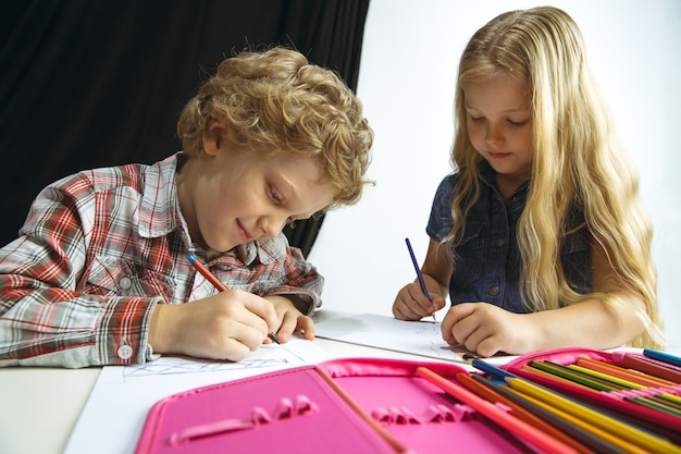 Free Photo Boy And Girl Preparing For School After A Long Summer Break Back To School Little Caucasian Models Drawing Together On White And Black Background Childhood Education Holidays Or Homework