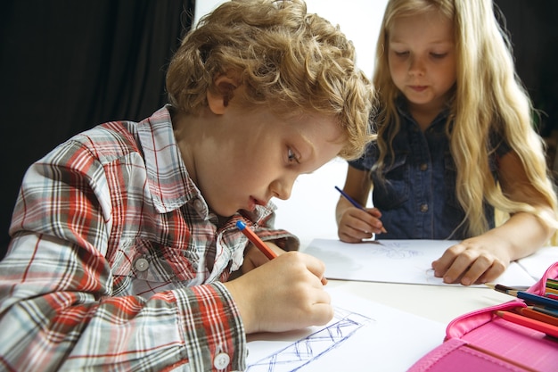 Free Photo Boy And Girl Preparing For School After A Long Summer Break Back To School Little Caucasian Models Drawing Together On White And Black Background Childhood Education Holidays Or Homework