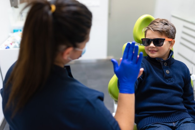 Boy gives five to the dentist Premium Photo