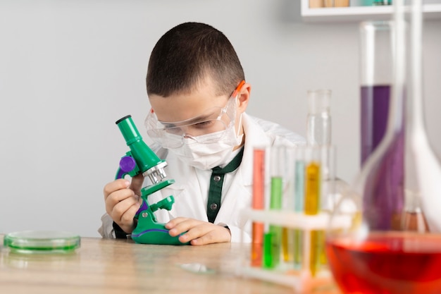 Free Photo | Boy in laboratory with microscope