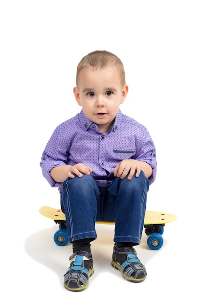 Premium Photo | Boy sitting on skateboard, isolated white background.