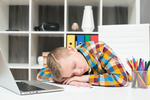 Boy Sleeping In Front Of Laptop On Desk Free Photo