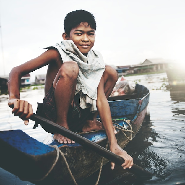 Boy traveling by boat in floating village. Premium Photo